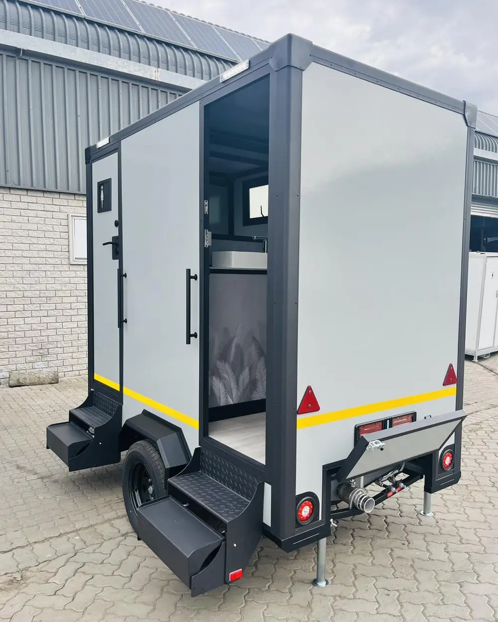 Restroom trailer rear steps and hitch