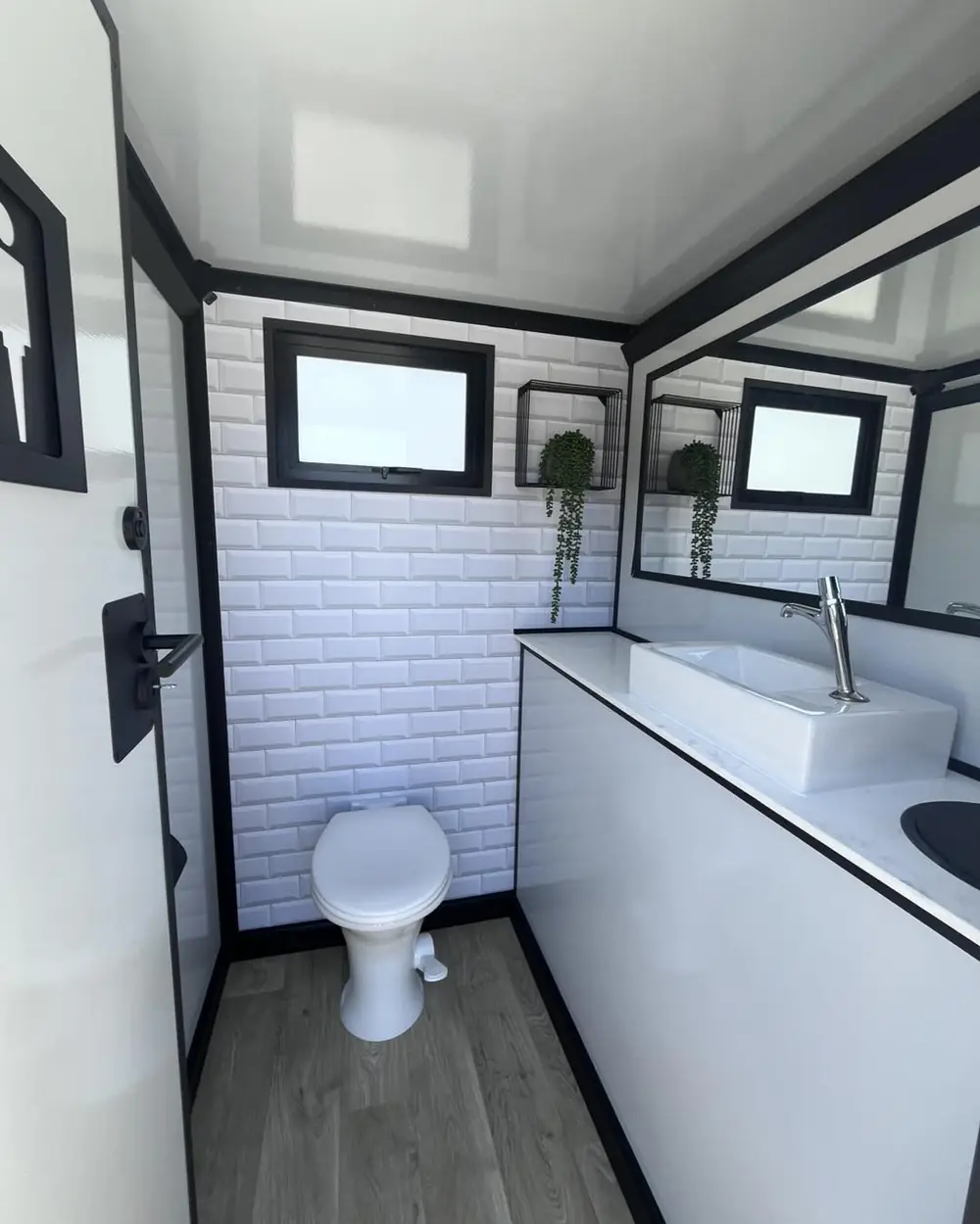 Bright restroom trailer stall with sink and mirror